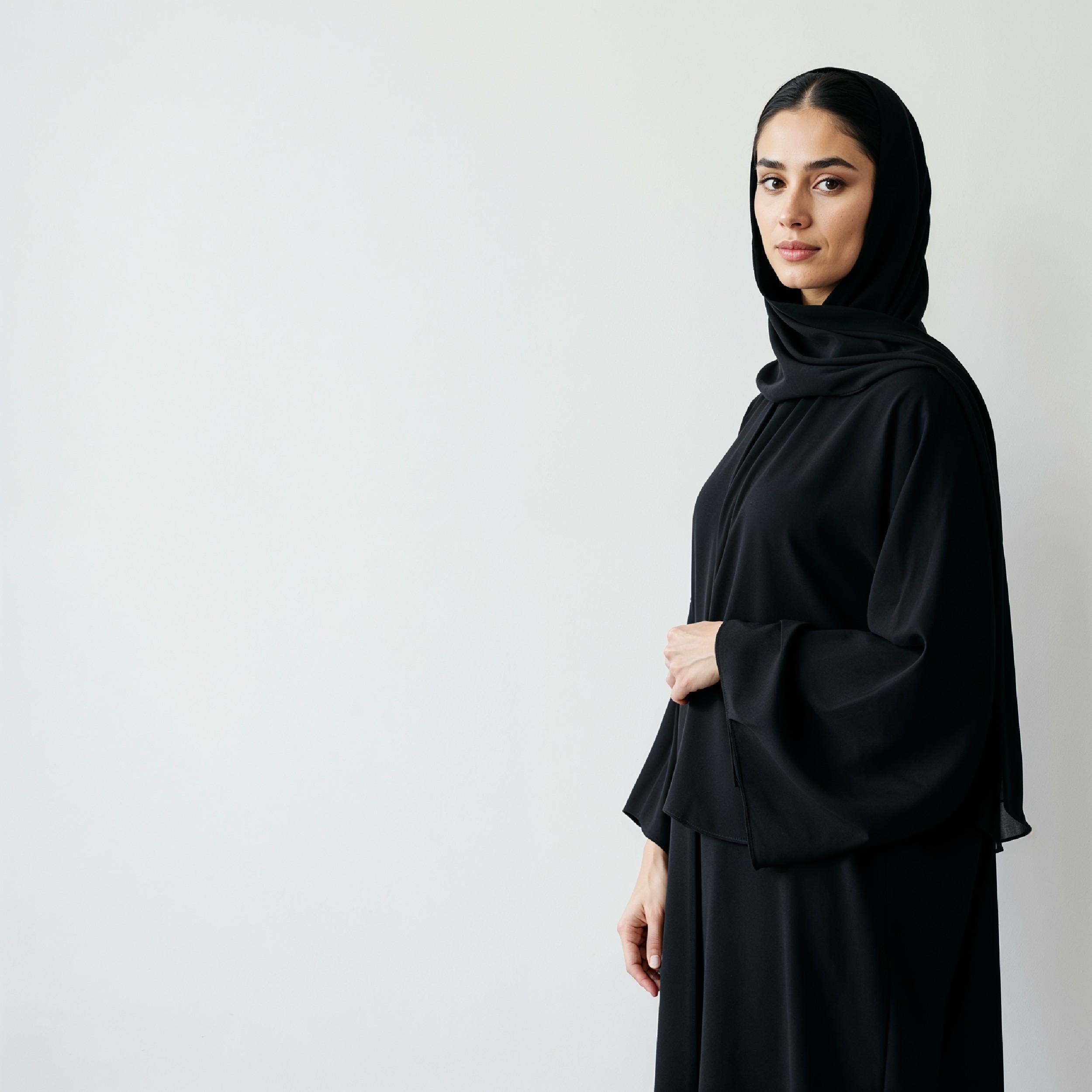 Elegant Muslim Woman Wearing Black Hijab and Abaya in Studio Portrait on Light Background