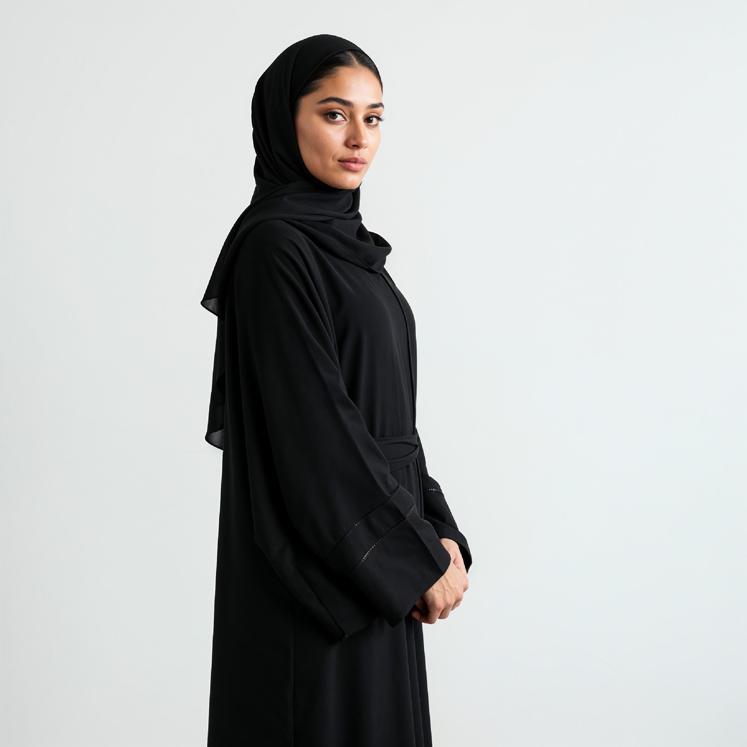 Elegant Muslim Woman Wearing Black Hijab and Abaya in Studio Portrait on Light Background