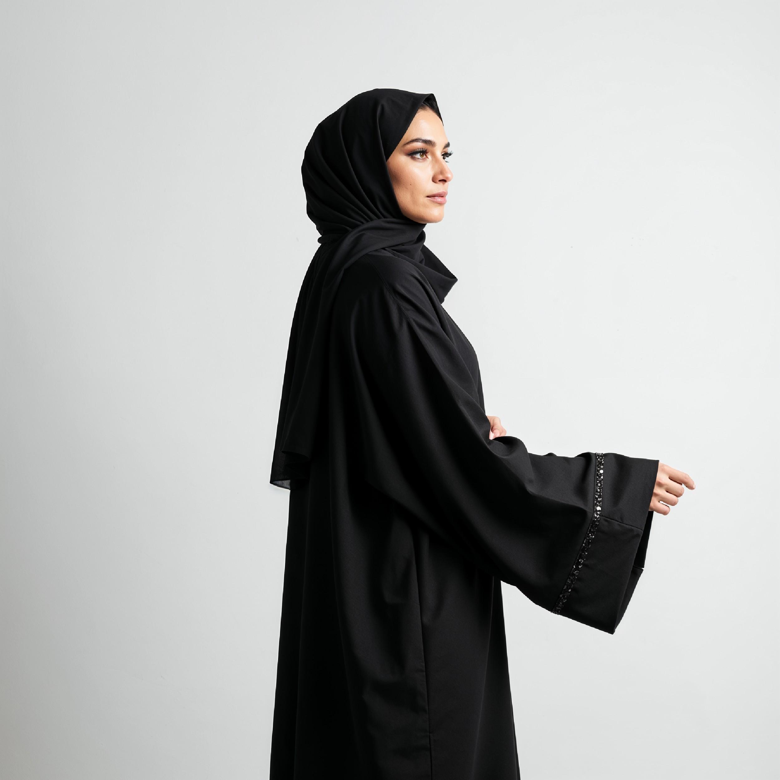 Elegant Muslim Woman Wearing Black Hijab and Abaya in Studio Portrait on Light Background