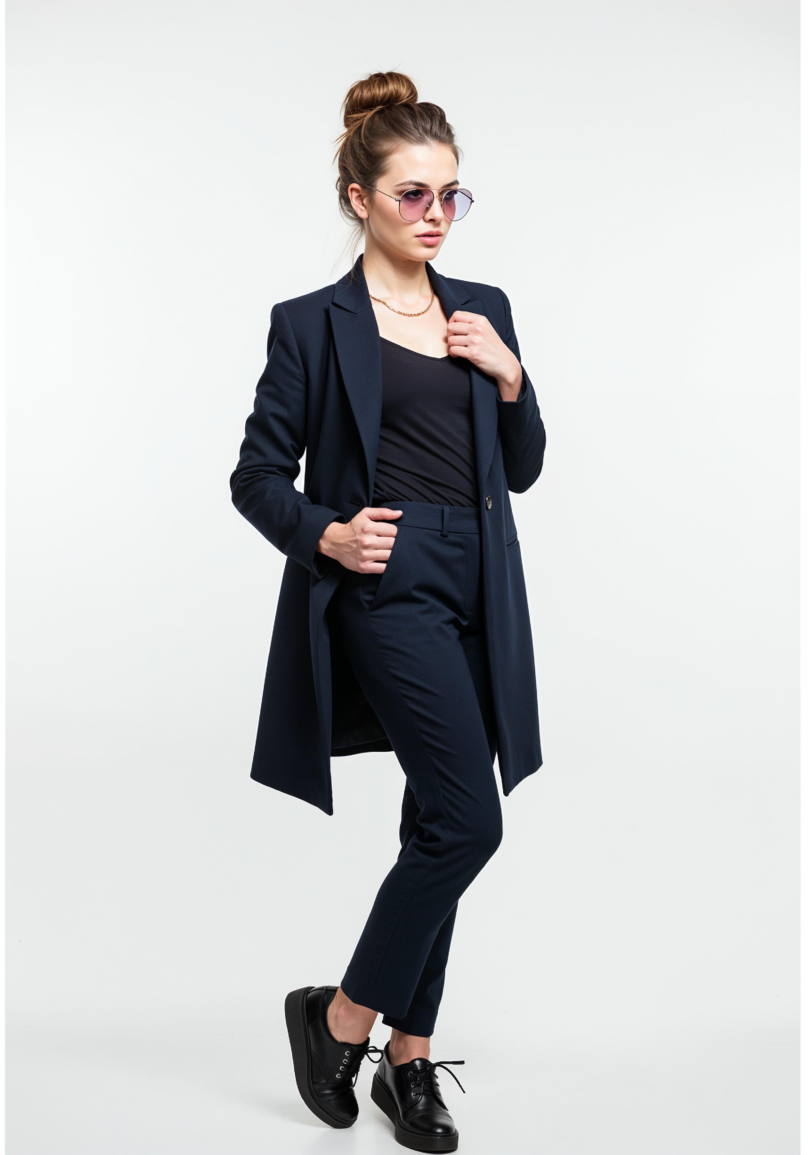 Elegant Young Woman in Coat and Matching Trousers Fashion Portrait